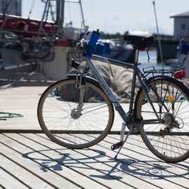 Sykkel parkert på brygge med båter i bakgrunnen